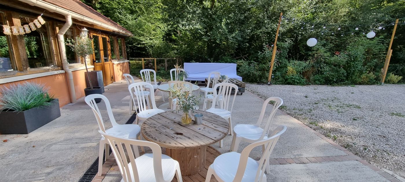 Terrasse avec tables en bois devant la maison forestière
